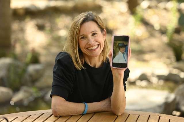 Kelli Sargent holds up her cell phone showing a photo of her mother.